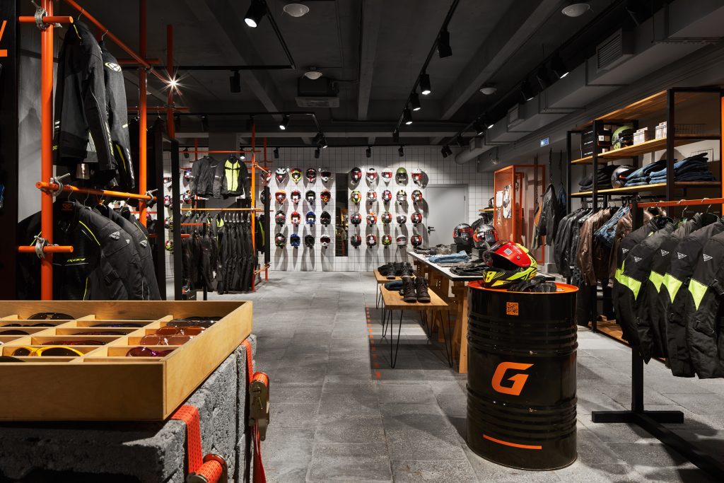 Интерьер мотосалона с разнообразным торговым обордованием и мерчандайзингом с зоной отдыха и коммерческим освещением для магазинов.