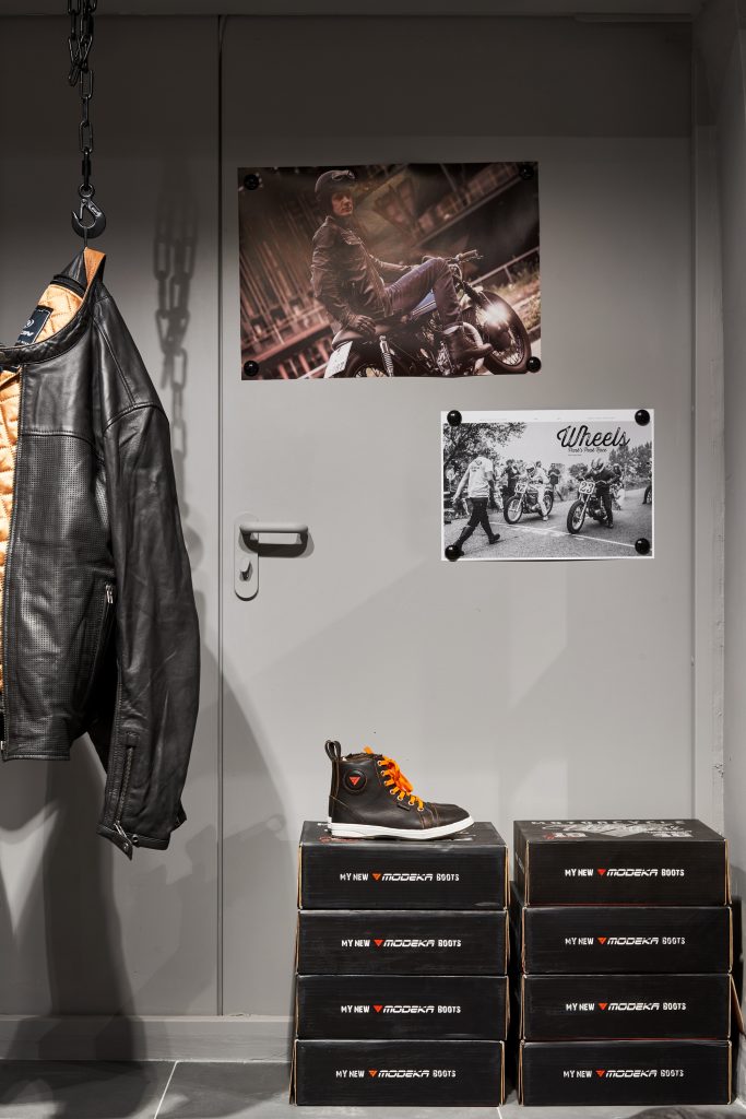 Дверь в мотосалоне. Как задекоровать и скрыть ее. Мотосалон с оранжевыми элементами и мотоэкипировкой в индустриальном стиле.