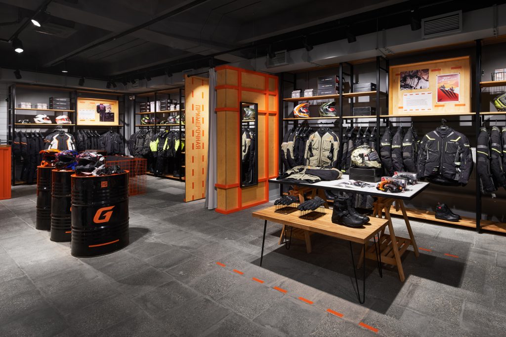 Торговый зал мотосалона с мотошлемами и современным торговым оборудованием. Дизайн магазина.